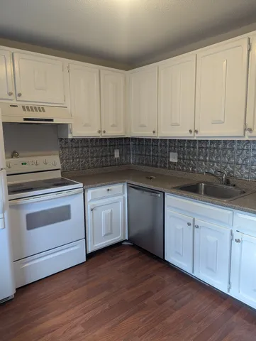 a kitchen with granite countertop white cabinets and white appliances