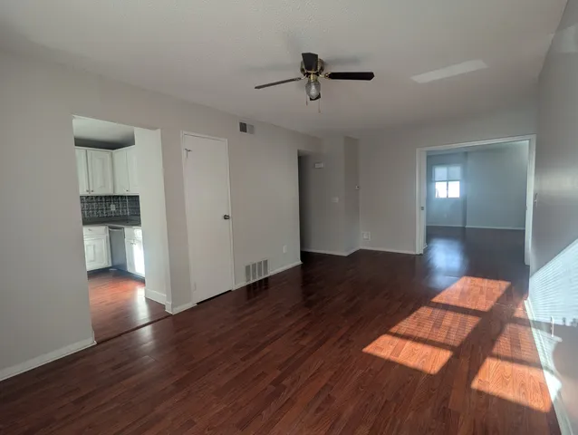 a view of empty room with wooden floor
