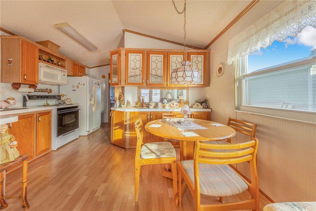 251 Patterson Road, Unit F22 Haines City, FL 33844 - Photo 13 of 50 a dining hall with stainless steel appliances granite countertop a stove a sink dishwasher and a refrigerator with wooden floor