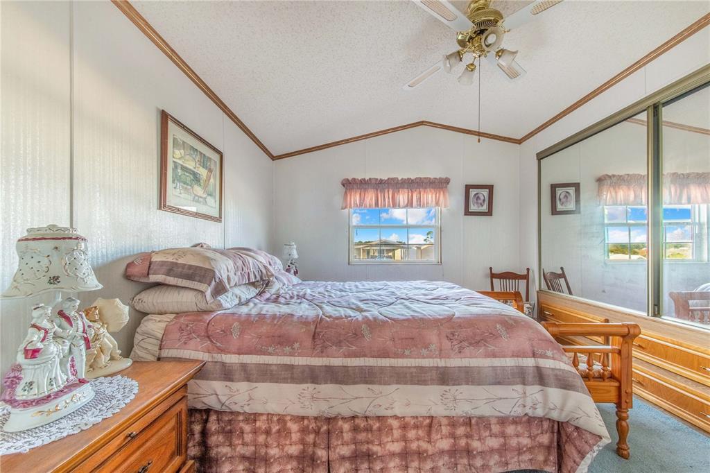 251 Patterson Road, Unit F22 Haines City, FL 33844 - Photo 16 of 50 a bedroom with two beds and a chandelier