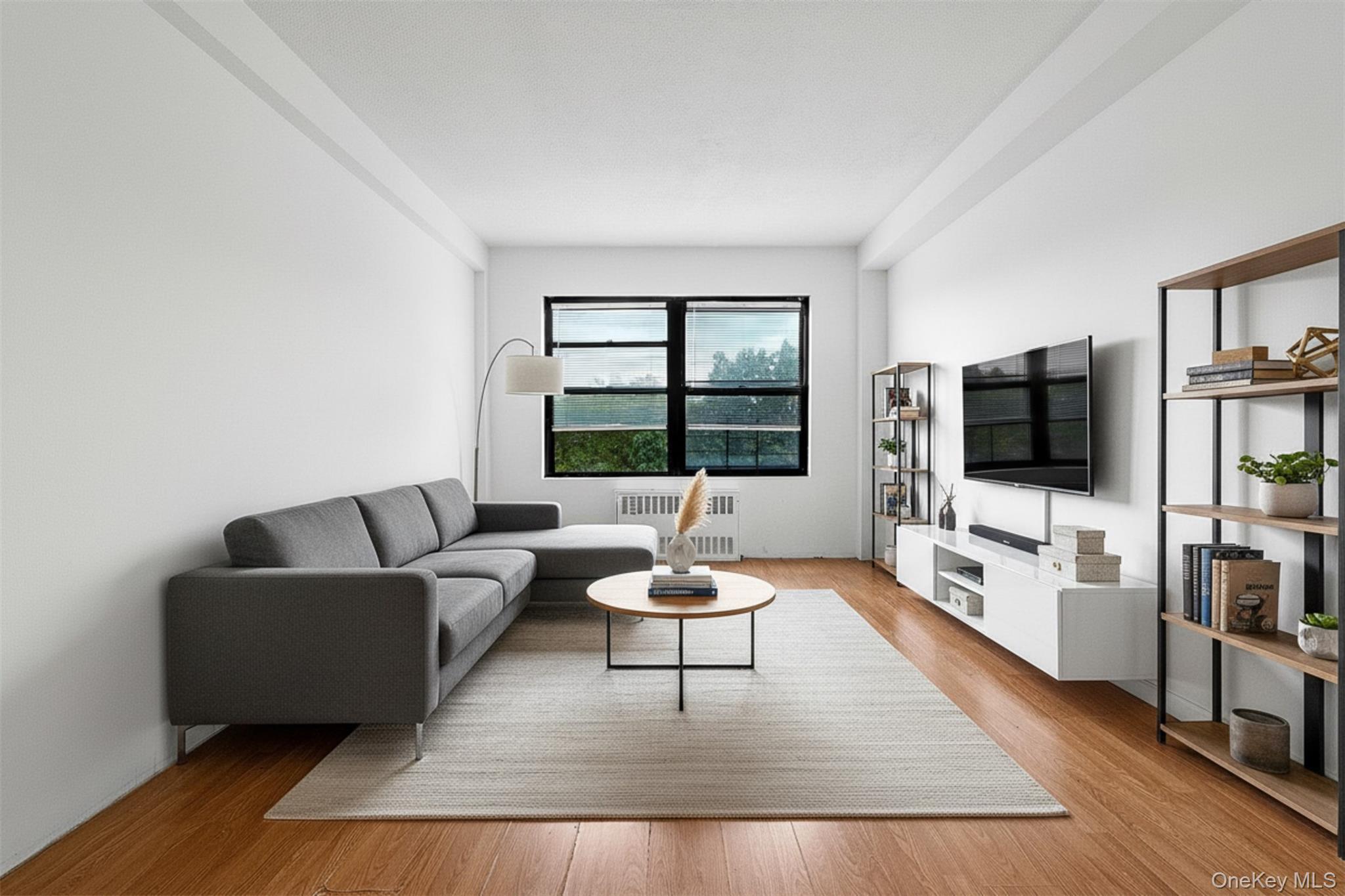 99-32 66th Road, Unit 5B Queens, NY 11374 - Photo 17 of 27 Living area featuring radiator and light wood-style floors