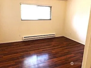 a view of a room with wooden floors and a window
