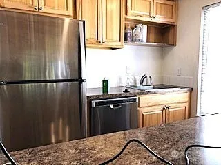 a kitchen with stainless steel appliances granite countertop a refrigerator and a sink