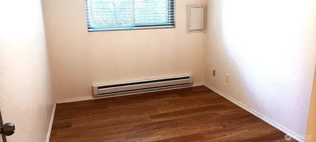 a view of an empty room with wooden floor