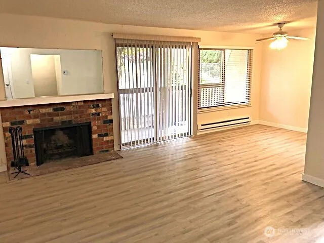 a view of a livingroom with wooden floor and a fireplace
