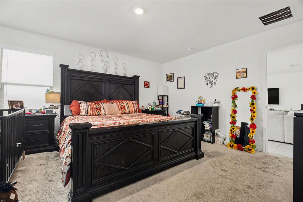 1711 High Perch Lane Forney, TX 75126 - Photo 7 of 16 a bedroom with a bed and cabinets