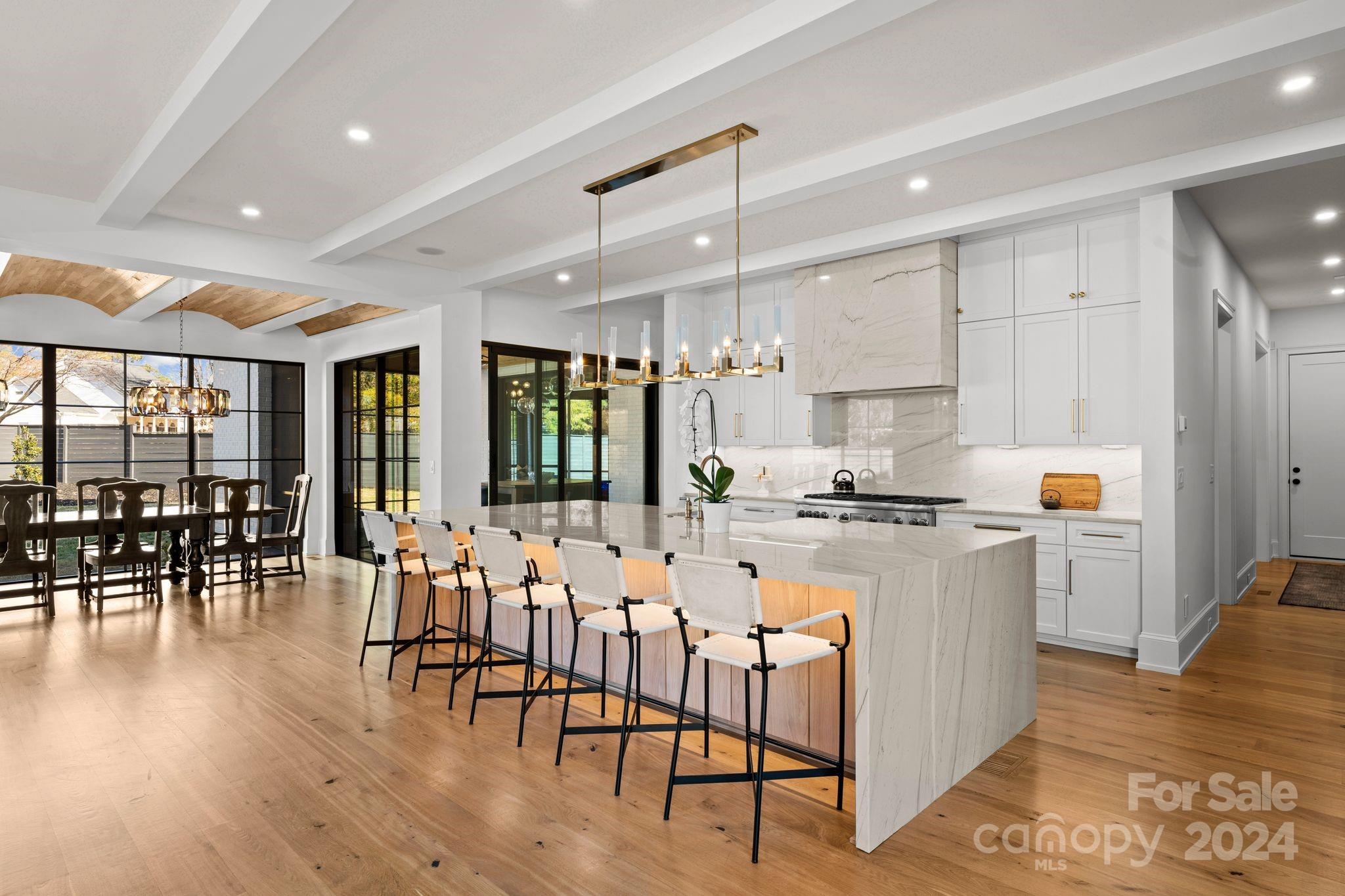 20218 Rainbow Circle Cornelius, NC 28031 - Photo 11 of 44 a kitchen with stainless steel appliances kitchen island granite countertop a stove a refrigerator a dining table and chairs with wooden floor