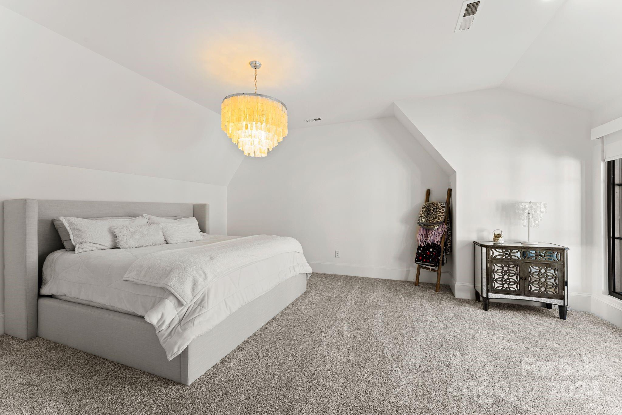 20218 Rainbow Circle Cornelius, NC 28031 - Photo 34 of 44 a bedroom with a bed and a chandelier