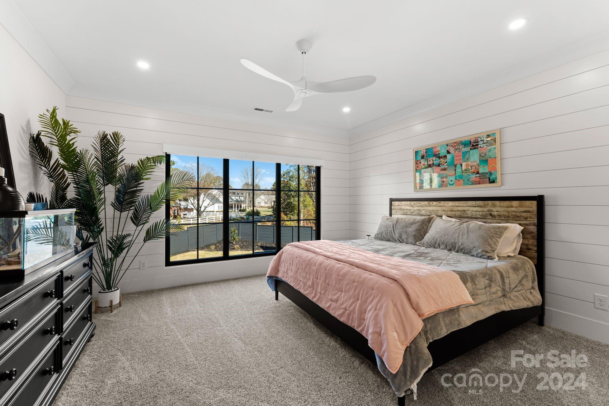 20218 Rainbow Circle Cornelius, NC 28031 - Photo 37 of 44 a spacious bedroom with a large bed and a large window