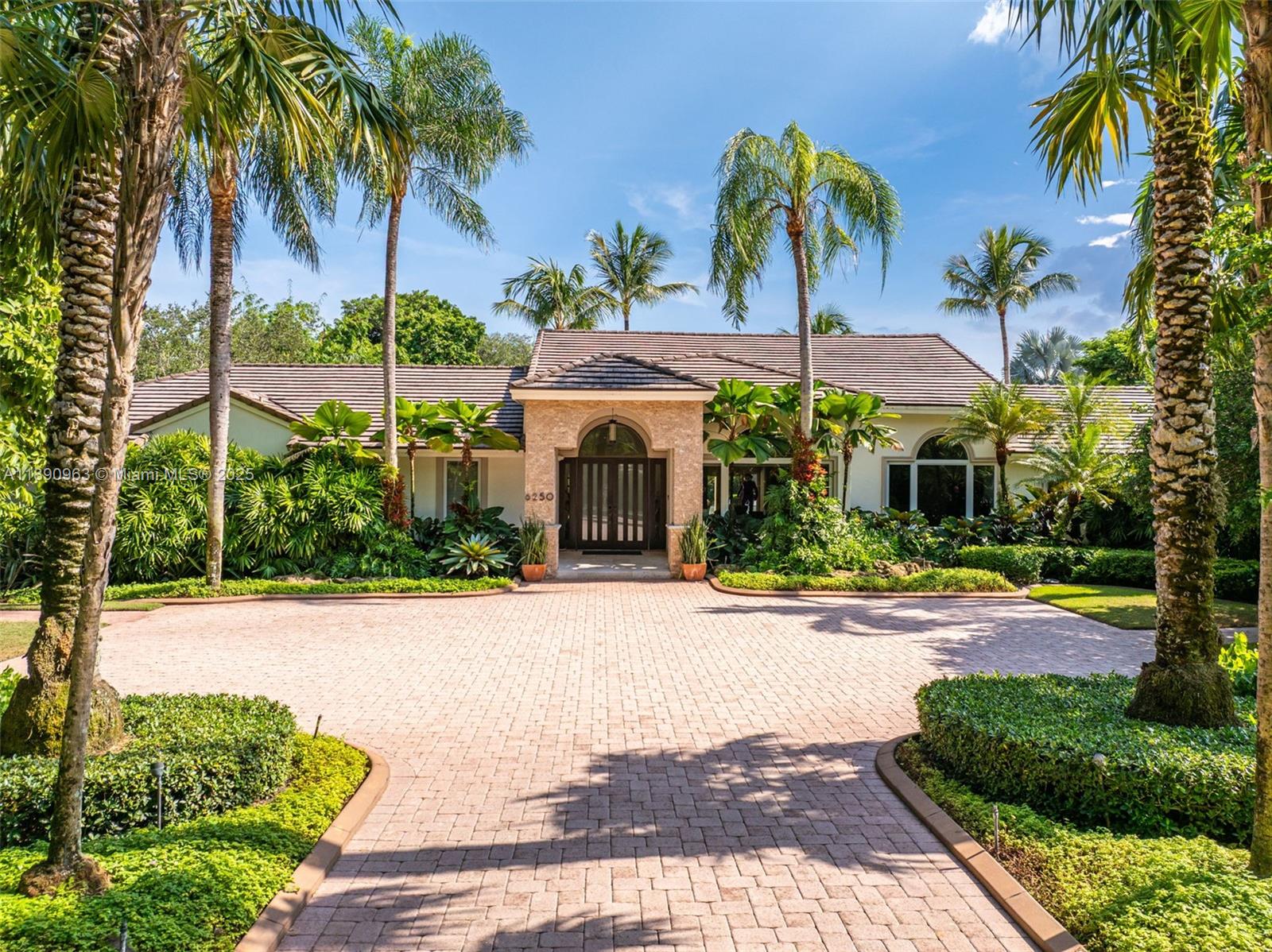 a front view of a house with a yard and potted plants