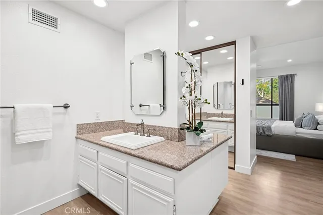 a bathroom with a granite countertop sink and a mirror