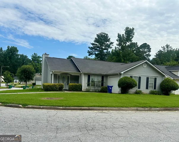 a front view of house with yard and green space
