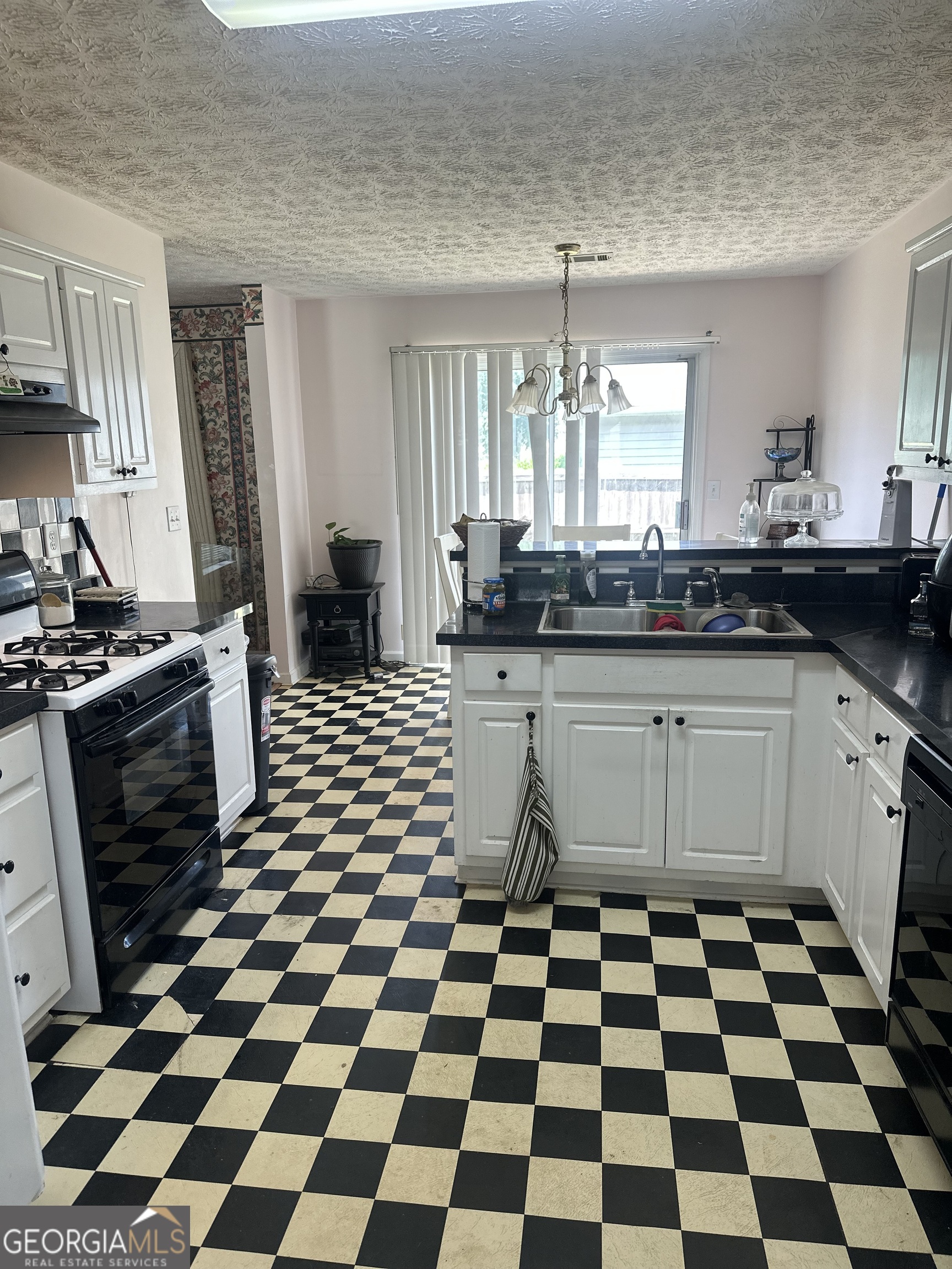 1616 Cobbs Creek Lane Decatur, GA 30032 - Photo 5 of 12 a kitchen with a checkered floor and white cabinets