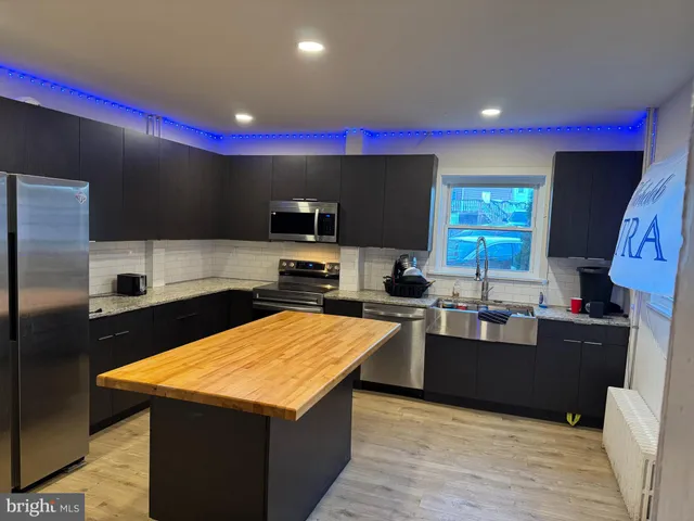 a kitchen with stainless steel appliances a sink a stove and a refrigerator