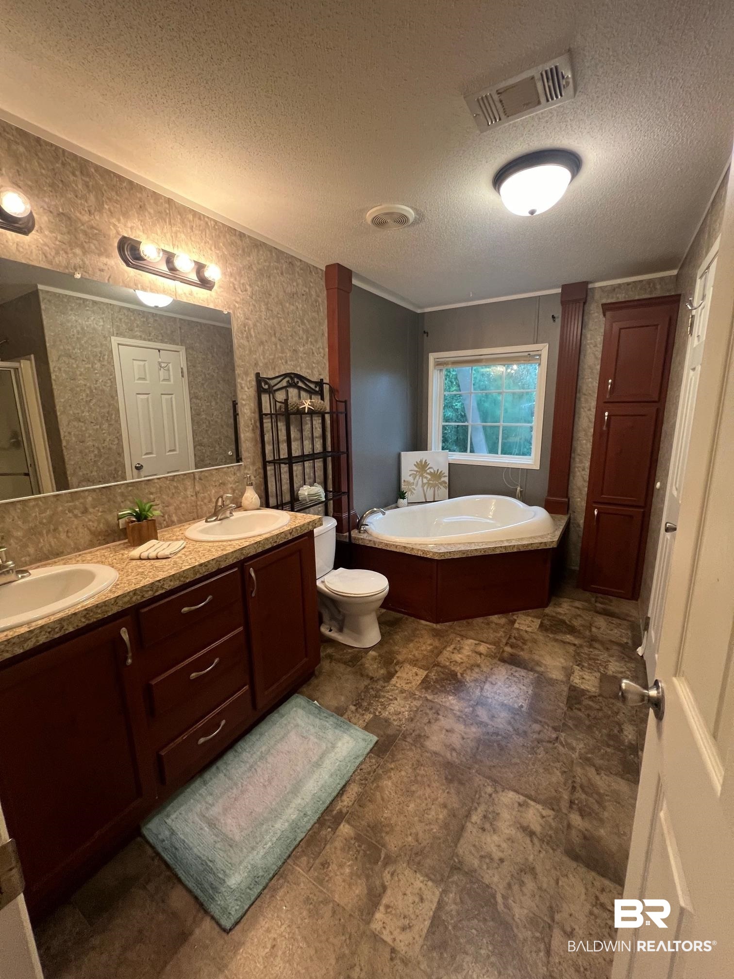 1985 Ridgewood Drive South Lillian, AL 36549 - Photo 8 of 40 Full bathroom featuring vanity, toilet, independent shower and bath, and a textured ceiling