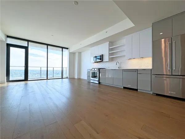 a view of a kitchen with a sink stove cabinets and empty room