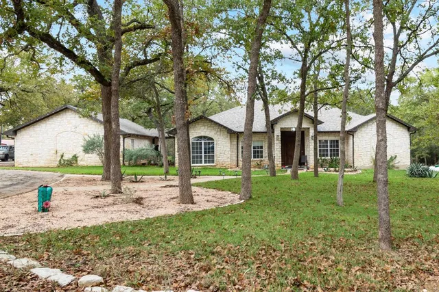 a view of a house with backyard and a tree