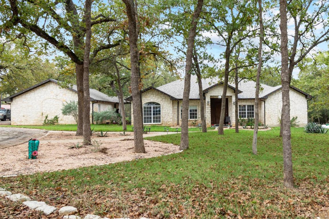 a view of a house with backyard and a tree