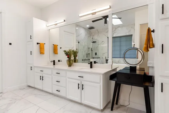 a bathroom with a double vanity sink mirror and shower