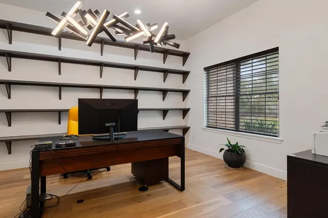 a view of a workspace with furniture and a window