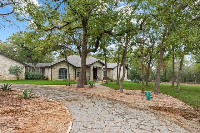 a front view of a house with a yard and trees