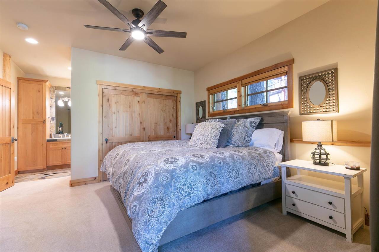 1755 Grouse Ridge Road Truckee, CA 96161 - Photo 9 of 20 a spacious bedroom with a bed and a chandelier