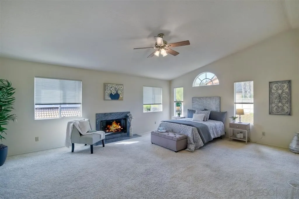 14228 Silver Ridge Road Poway, CA 92064 - Photo 17 of 25 a spacious bedroom with a bed and a fireplace