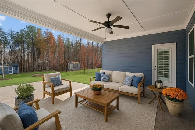 a living room with patio furniture and a garden