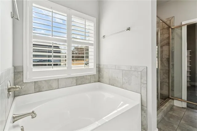 a white bath tub sitting in a bathroom next to a window