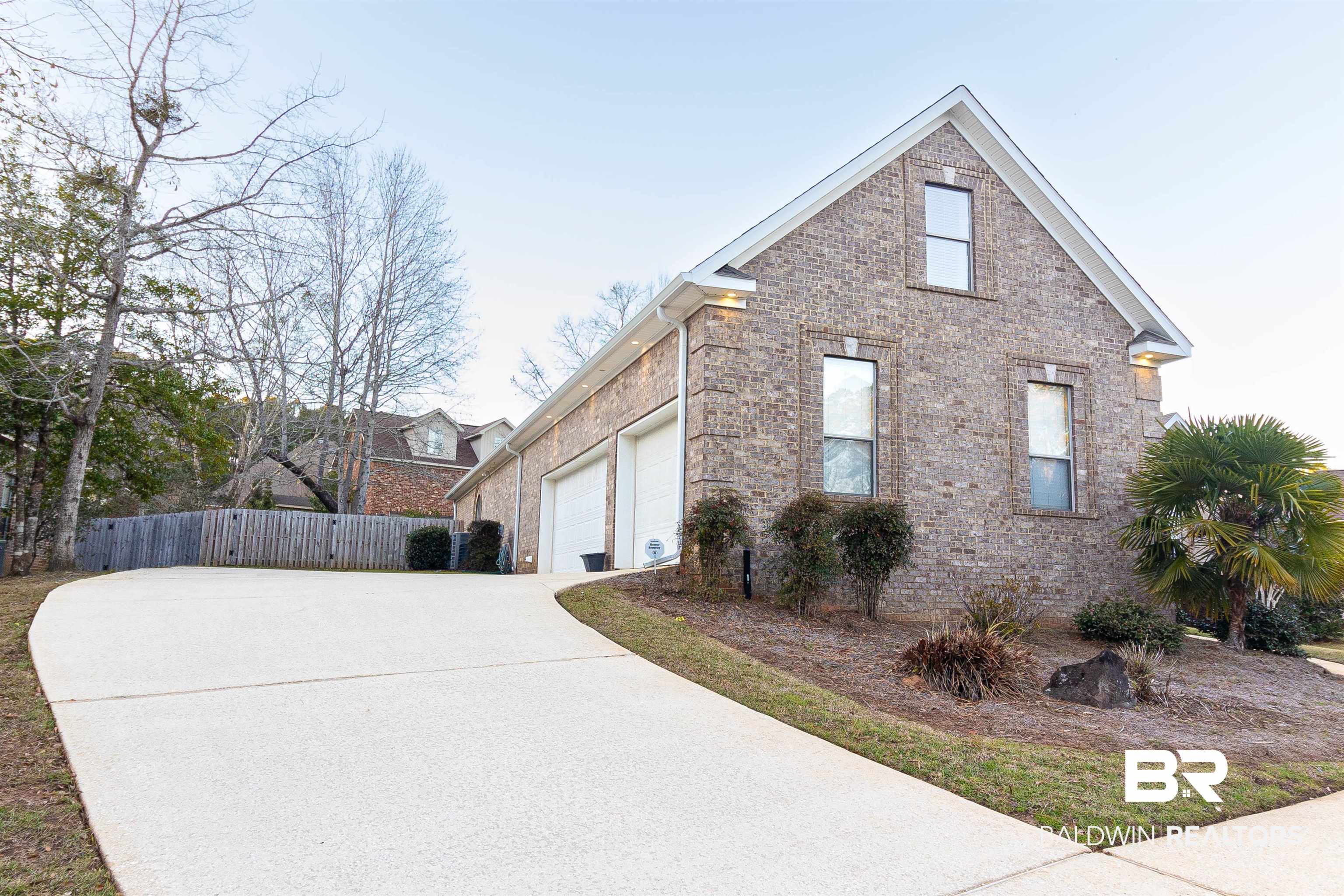 7211 Rushing Water Court Daphne, AL 36527 - Photo 3 of 51 View of side of property featuring driveway, brick siding, an attached garage, and fence