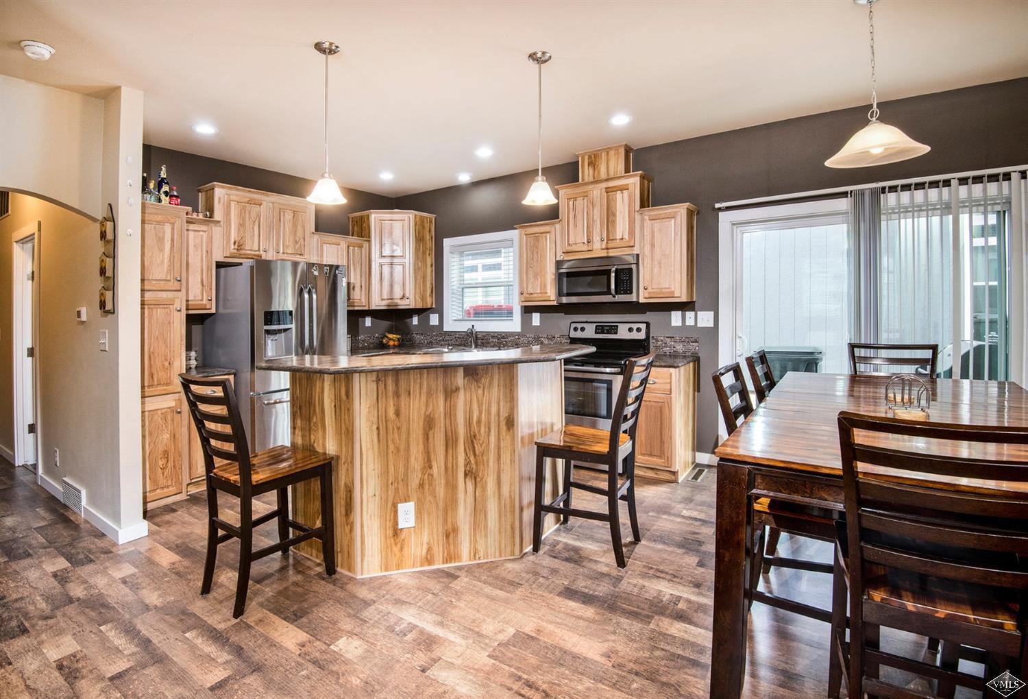 10 Salmon Loop Gypsum, CO 81637 - Photo 5 of 25 a kitchen with stainless steel appliances kitchen island granite countertop a table chairs and a refrigerator