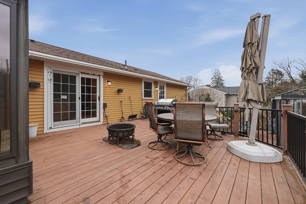 128 Derby Street Worcester, MA 01604 - Photo 27 of 34 a view of a deck with table and chairs barbeque with wooden floor and fence
