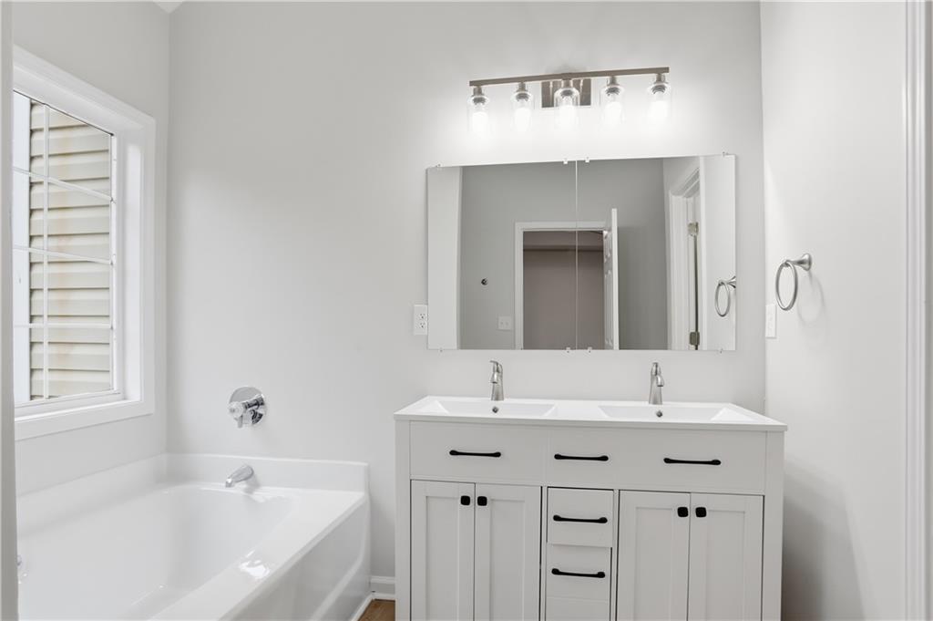 5556 Claridge Circle Stonecrest, GA 30038 - Photo 22 of 25 a bathroom with a bathtub sink and mirror