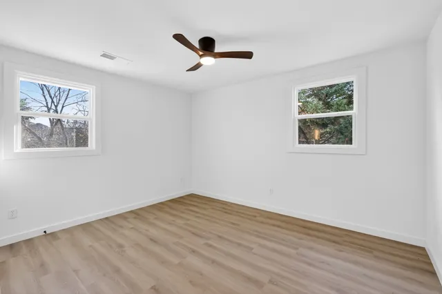 a view of empty room with wooden floor