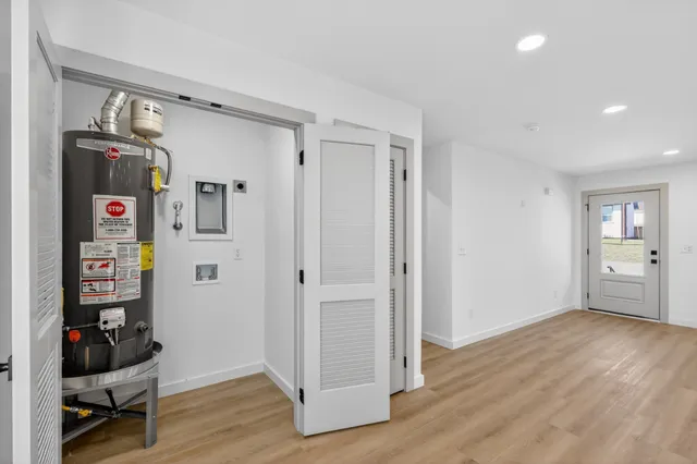 a view of an empty room with wooden floor and closet