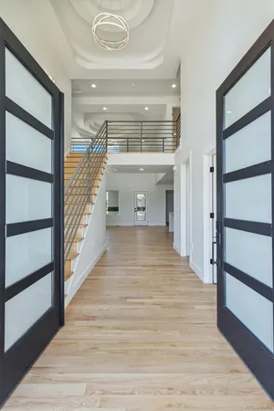 a view of a hallway with wooden floor and staircase