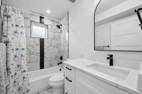 a bathroom with a sink toilet vanity and shower