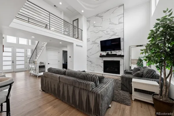 a living room with furniture a flat screen tv and a fireplace