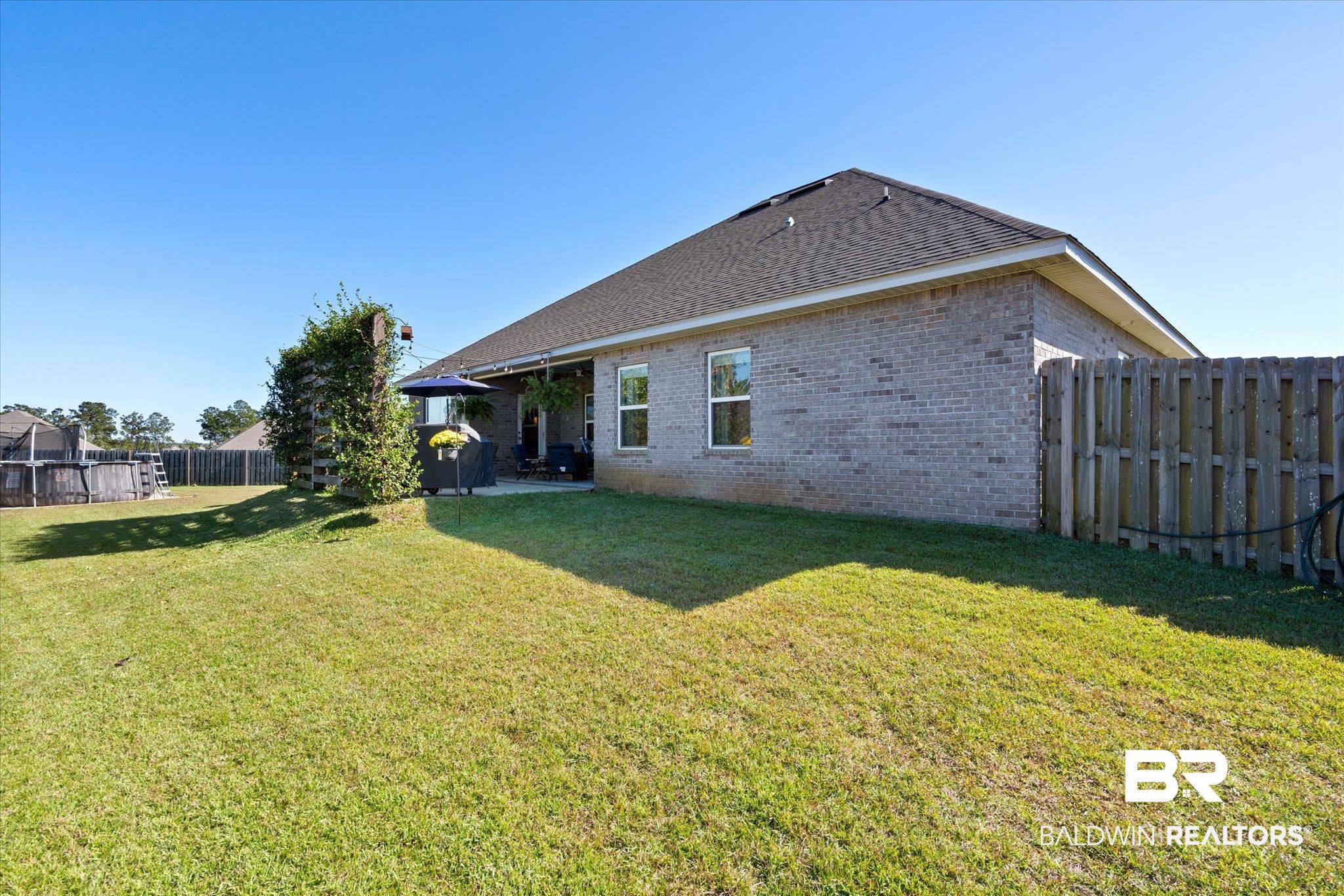 12899 Sanderling Loop Daphne, AL 36527 - Photo 2 of 28 Rear view of house featuring a lawn