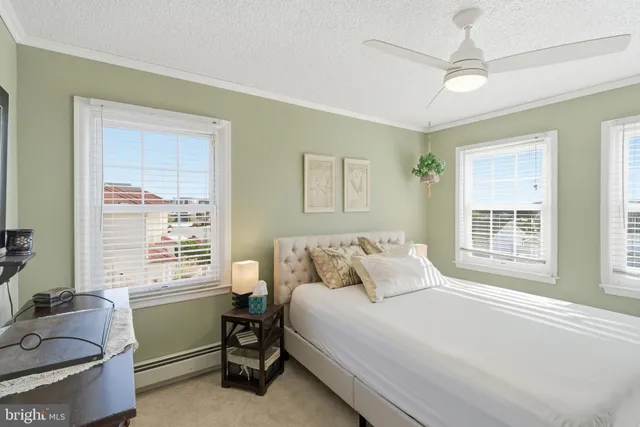 a bedroom with a bed and a dresser next to a window