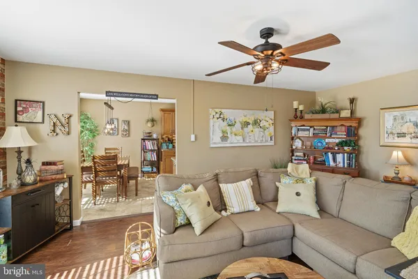 a living room with furniture kitchen view and a window