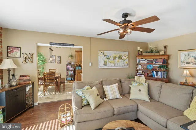 a living room with furniture kitchen view and a window
