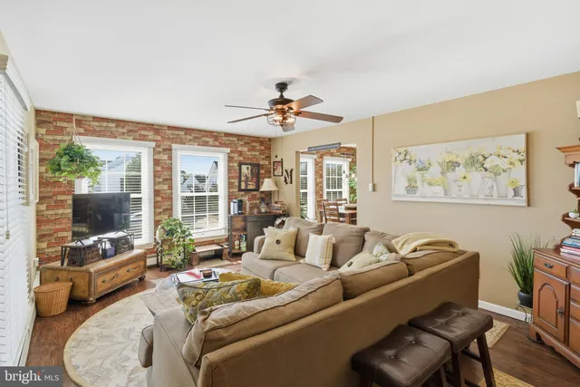 a living room with furniture a flat screen tv and a large window