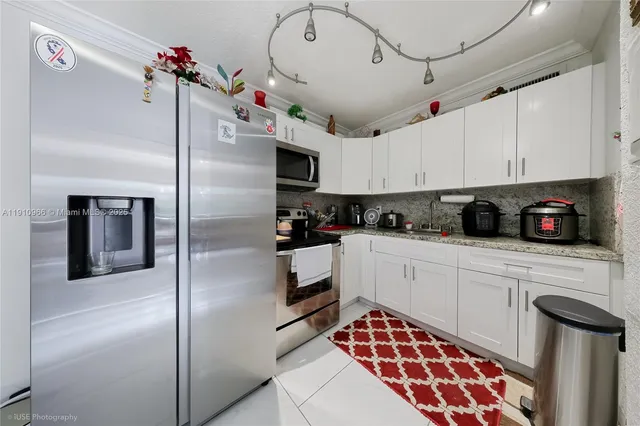 a kitchen with stainless steel appliances granite countertop a sink a stove and cabinets