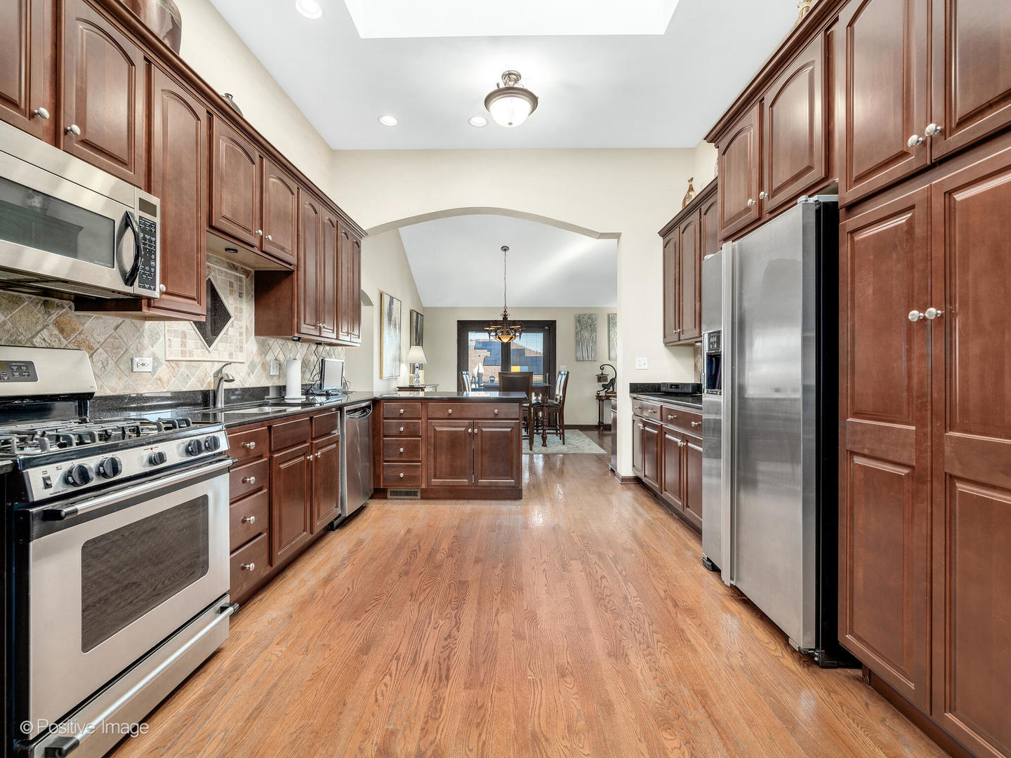 1306 Chauser Lane Woodridge, IL 60517 - Photo 14 of 40 a kitchen with stainless steel appliances granite countertop a stove cabinets and wooden floor