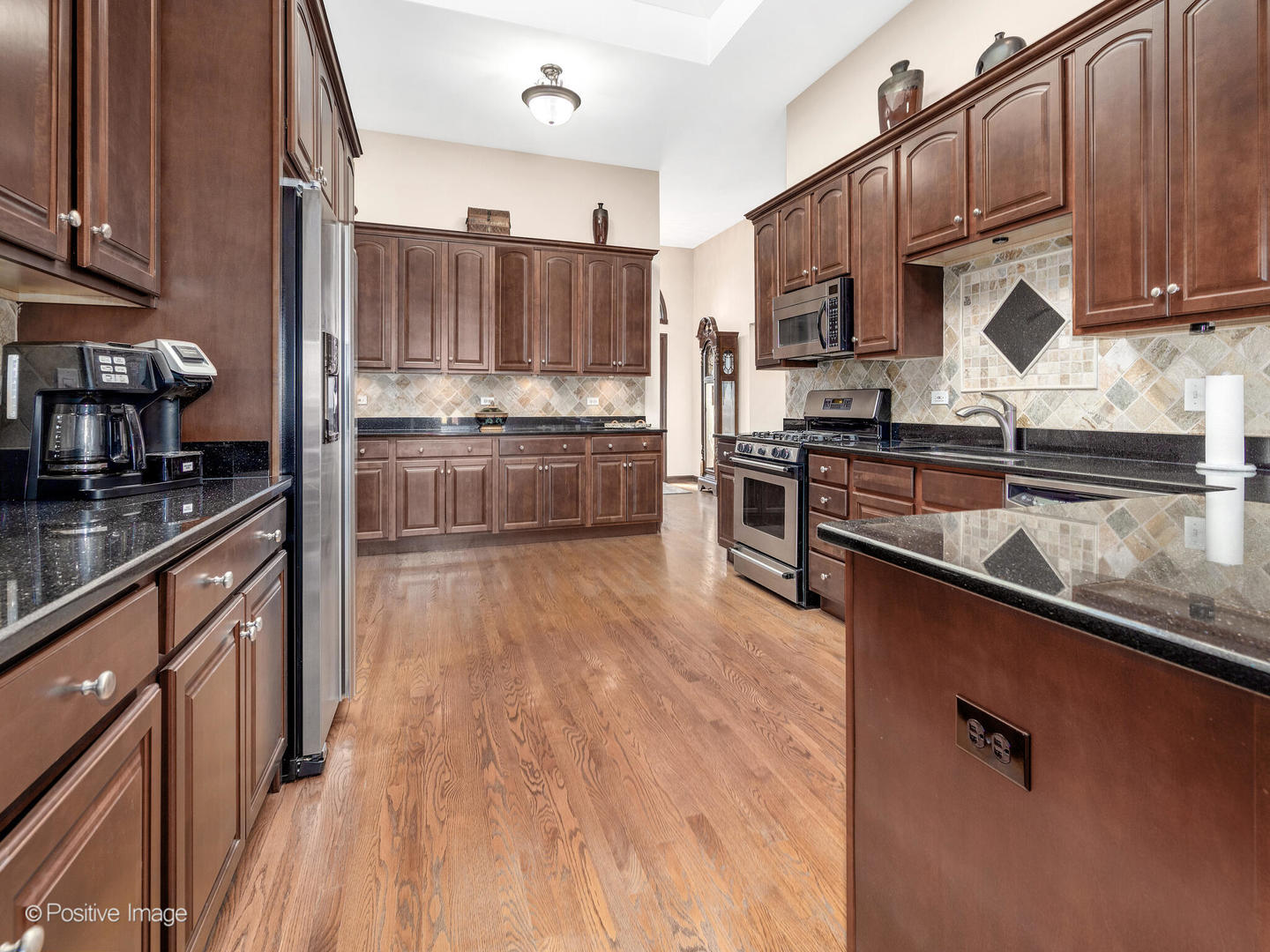 1306 Chauser Lane Woodridge, IL 60517 - Photo 16 of 40 a kitchen with stainless steel appliances wooden cabinets and a stove top oven