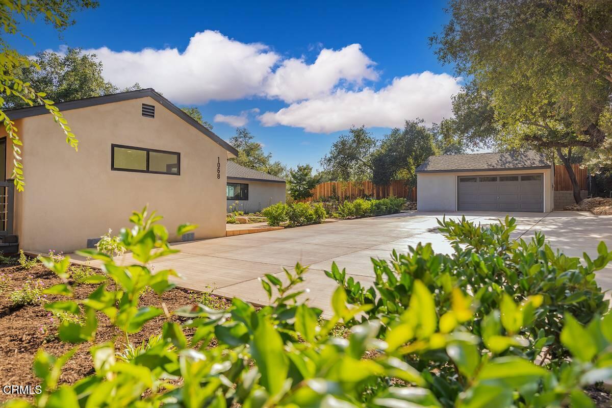 1068 Cuyama Road Ojai, CA 93023 - Photo 2 of 23 a front view of a house with a yard and fountain in middle of the road