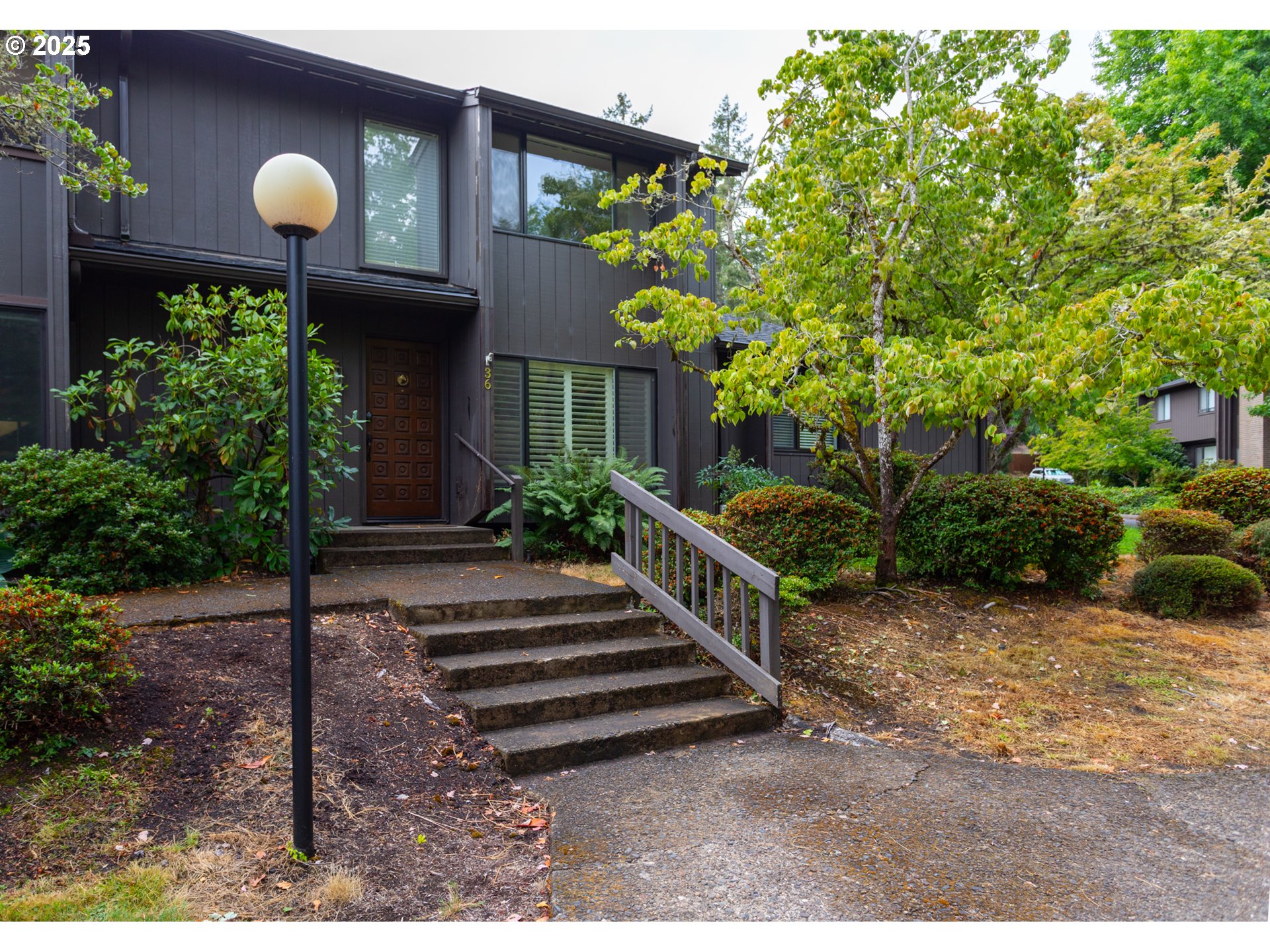 a front view of a house with a yard and potted plants