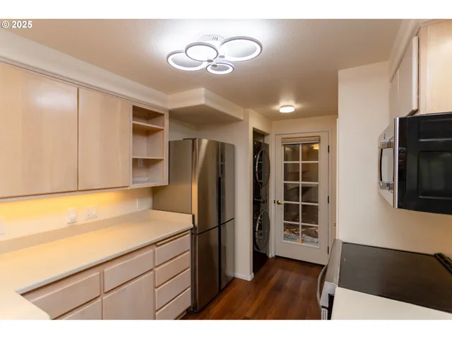 a kitchen with stainless steel appliances granite countertop a refrigerator and a stove top oven