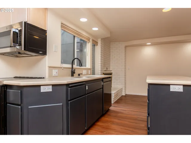a kitchen with a sink appliances and cabinets